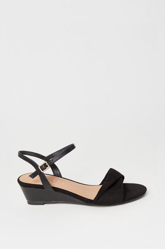 Wide fit design offers a comfortable and accommodating fit
Soft twist detailing adds an elegant touch to the upper
Low wedge heel provides a subtle lift while ensuring all-day wearability
Ankle strap with buckle closure ensures a secure and adjustable fit
Open-toe silhouette allows for breathability during warmer months

Exuding sophistication and versatility, these sandals from Wallis are the perfect choice for formal occasions. The wide fit design ensures a comfortable and accommodating fit, while the soft twist detailing adds an elegant touch to the upper. The low wedge heel provides a subtle lift while ensuring all-day wearability, making them ideal for events like weddings, races, or graduations. Style them with a tailored dress or a chic jumpsuit for a polished and refined look that radiates confidence and grace.