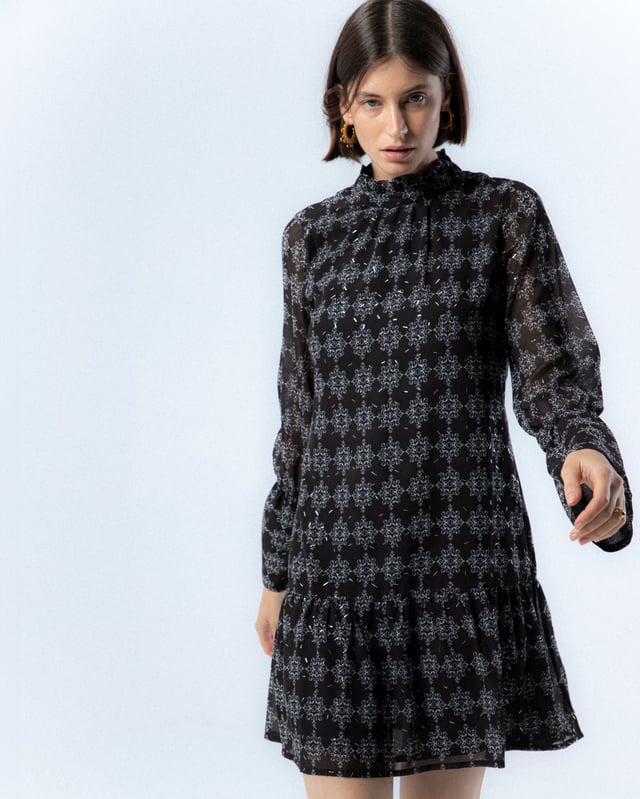 El vestido con volante Catalina en azul te hará sentir la frescura del invierno. Con su diseño elegante y detalles de volantes, esta prenda añade un toque de sofisticación y movimiento a tu look. Perfecto para cualquier ocasión, realza tu silueta con su lazada en la cintura.
 
 
 
 Vestido corto con cuello redondo. 
 
 Manga larga con puño elastico y volante a la altura del codo. 
 
 Cierre en espalda con cremallera. 
 
 Tejido estampado geométrico con detalles de foil dorado.