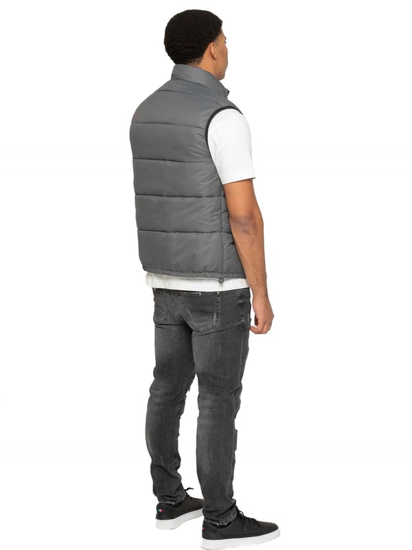Embodying both fashion and function, the Enzo Mens Puffer Gilet boasts a water-resistant design and a high neck for added warmth. It also offers secure storage with zipped side pockets, and a custom fit with its elasticated hem and adjustable toggle. The full zip-up front and lined interior provide ultimate comfort and practicality. With a EZ branded badge on the chest, this gilet is crafted from durable 100% polyester and is conveniently machine washable.