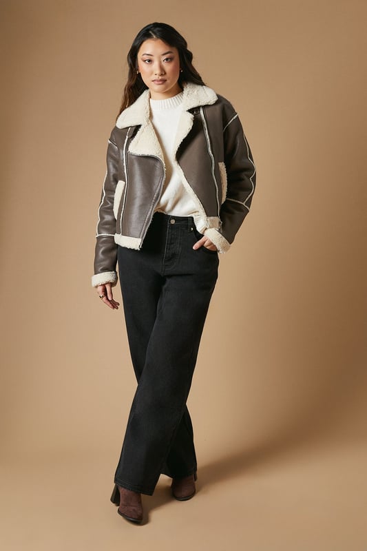 Striking contrast borg detailing for added warmth and style
        Asymmetrical zip front closure for a modern edge
        Oversized collar for a bold, fashion-forward look
        Cropped length perfect for layering
        Versatile design suitable for various casual occasions
    
    This PU borg detail collared zip jacket from Oasis is the epitome of cool-weather chic. The contrasting borg lining not only adds a cosy touch but also creates a striking visual appeal. Its asymmetrical zip closure and oversized collar lend a contemporary edge to your ensemble. The cropped silhouette is ideal for showcasing high-waisted bottoms, as demonstrated by the model pairing it with wide-leg trousers. For a casual day out, style it with your favourite jeans and trainers. Alternatively, dress it up for an evening with friends by layering it over a fitted dress and ankle boots. This jacket is a versatile piece that will quickly become a go-to in your autumn and winter wardrobe, perfect for family gatherings, weekend brunches, or casual outings where you want to make a stylish statement without compromising on comfort.