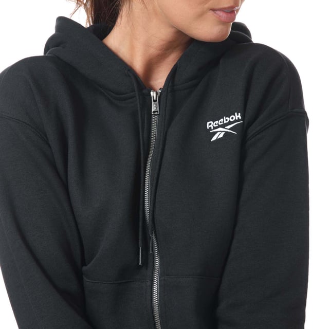 Womens Reebok Identity Zip- Up Track Top in black.- Drawcord-adjustable hood.- Long sleeves with ribbed cuffs.- Full zip fastening.- Kangaroo pocket.- Ribbed hem.- Small logo.- Oversize fit.- Main Material: 80% Cotton  20% Polyester (Recycled). Rib Part: 95% Cotton  5% Elastane. - Ref:GL2561