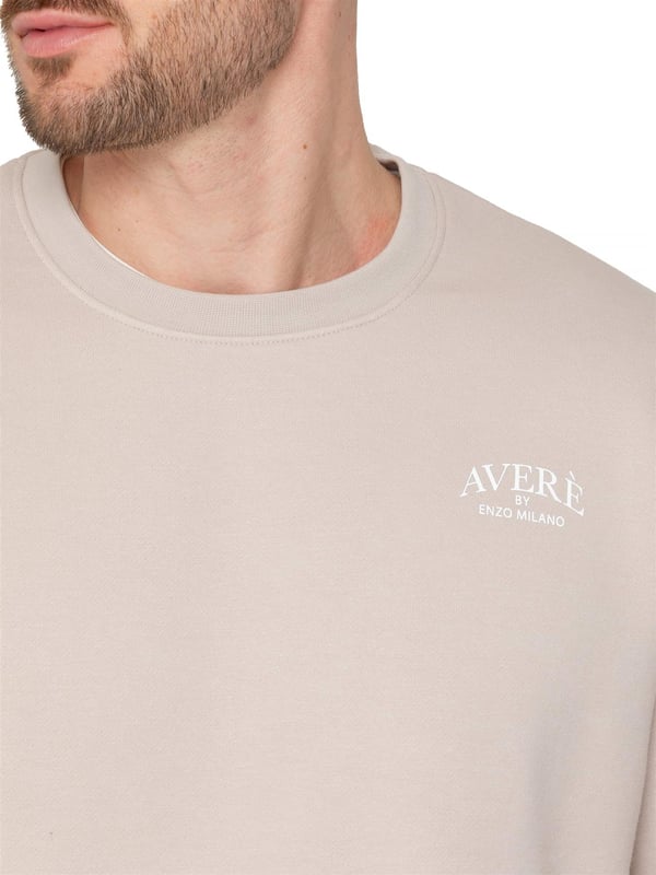 El suéter oversized para hombre Averè de Enzo Milano presenta un ajuste relajado y casual, perfecto tanto para descansar como para el uso diario. El frente muestra un discreto logotipo de Averè en el pecho. El suéter tiene mangas largas y un cuello redondo acanalado con puños acanalados, lo que le da una silueta limpia y clásica. La tela suave y el forro de felpa garantizan comodidad, mientras que el corte de hombro caído mejora el aspecto oversized. La parte trasera permanece lisa, manteniendo un estilo simple y elegante. Ideal para combinar con pantalones de chándal o jeans para un atuendo relajado.