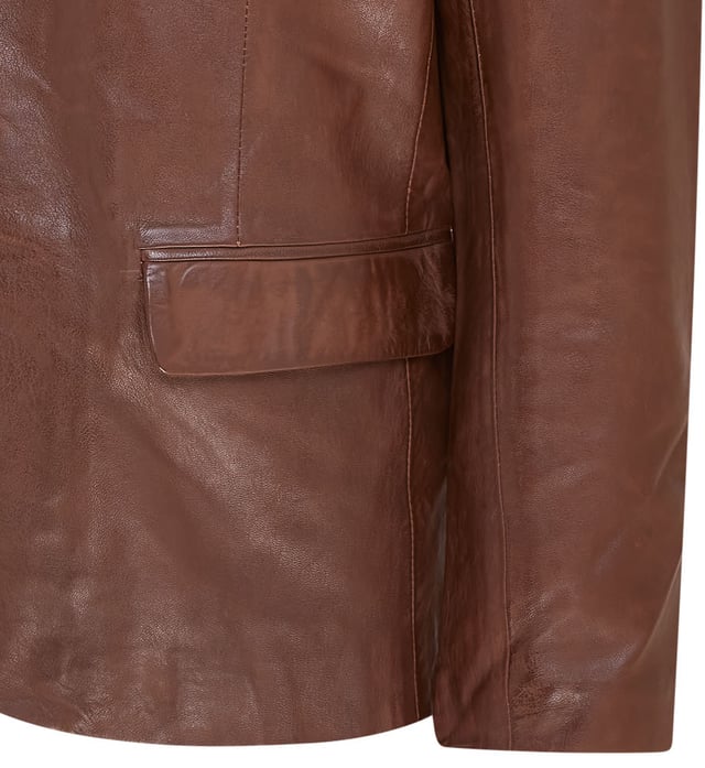 Una gran opción para crear un look sofisticado para ocasiones más formales, esta chaqueta blazer está confeccionada en nuestro cuero napa de grano completo de primera calidad. Con un solo pecho, dos botones y bolsillos con solapa ubicados en la cintura, esta chaqueta viene en el apreciado estilo tradicional. La chaqueta ha sido diseñada con una silueta delgada y se ajusta a la cintura para lograr el ajuste perfecto, con cuatro botones en cada puño abierto y una sola abertura en la parte trasera de la chaqueta también introducida para este propósito. Presentamos esta versión contemporánea del blazer clásico en combinaciones de colores negro y marrón para dos alternativas versátiles. • 100% cuero napa ultra suave de primera calidad • Blazer formal de un solo pecho con dos botones • 3 bolsillos externos y 2 internos • Cuatro botones en cada puño y una sola abertura en la parte trasera de la chaqueta