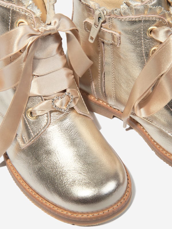 Introducing the exquisite Girls Leather Lace Up Boots in Gold by andanines, a deluxe addition to any young fashionista's AW2024 collection. These exceptional boots blend timeless design with chic modernity, perfect for stylish adventures. Key features include: Luxurious Craftsmanship: Expertly made in Spain with premium leather for a refined look and resilience. Striking Gold colour: A dazzling gold finish that captures the eye and elevates any outfit. Secure Lace-Up Design: Ensures a comfortable, adjustable fit for growing feet. Versatile Style: Ideal for both special occasions and everyday wear, offering endless pairing possibilities.Revamp your girl's wardrobe with these stunning Gold Lace Up Boots from andanines. Witness elegance and style in every step she takes!