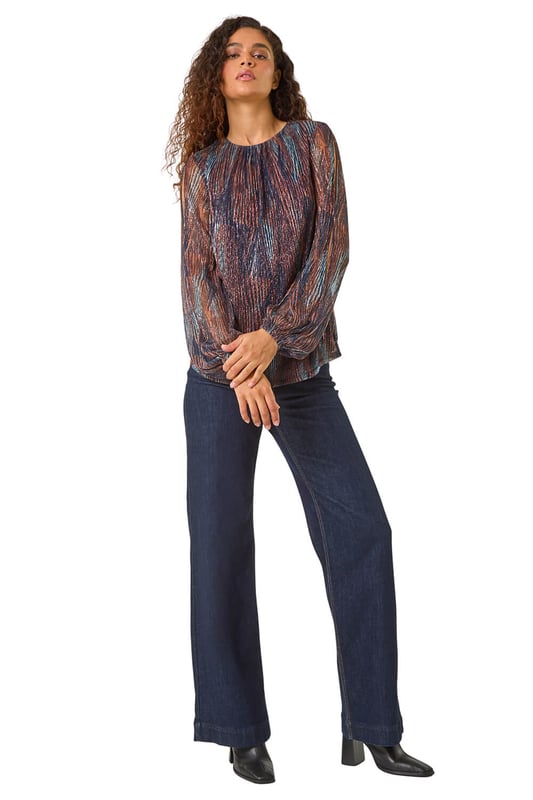Shimmer Plisse Top from Roman. Unleash your style with our eye-catching geometric print plisse top, perfect for the Autumn Winter season. The classic round neckline and shirred cuffs offer a sophisticated touch, while the soft, shimmering fabric adds a hint of glamour. Pair with faux leather pants and ankle boots for a trendy party outfit!