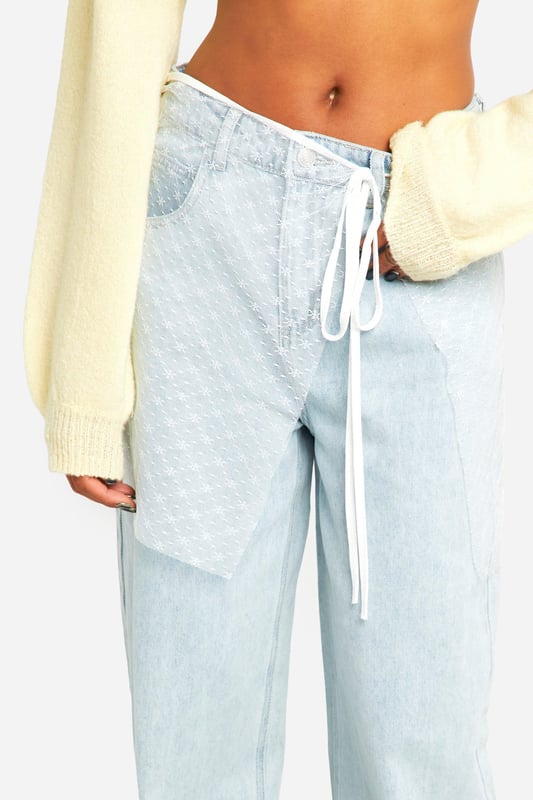 Detachable Lace Tie Skirt Overlay And Washed Wide Leg Denim Jeans Secure a wardrobe staple this season with this denim skirt from our latest collection. The perfect tool for day-to-night dressing, denim skirts for women are a wardrobe staple which never go out of style. Featuring a rigid denim fabric that can be dressed up or down, we're talking wear anywhere and everywhere kinda vibes. Let your style transcend the seasons and rock a denim skirt with a striped top and flat chunky boots. Versatile all year round, this jean skirt looks just as dreamy worn with a jumper or a crop top, winning. We love a white denim skirt with a cute top for summer fits and classic black denim skirts for easy throw-on-and-go looks.Style: Wide Leg JeansDesign: WashedFabric: Cotton