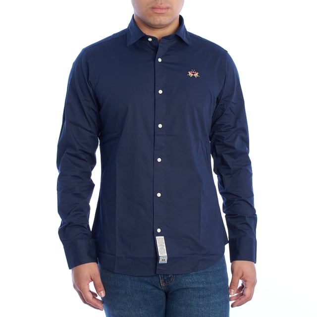 Camisa clásica de hombre La Martina. 

Una prenda imprescindible en el armario masculino que equilibra a la perfección estilo y funcionalidad. Esta camisa de La Martina destaca por su diseño atemporal y detalles sofisticados que reflejan la esencia de la marca.

Detalles:

- Camisa de manga larga con cierre frontal de botones.
- Diseño de corte ajustado que se adapta perfectamente al cuerpo.
- Confeccionada en algodón de alta calidad, ligero y transpirable.
- Logotipo de La Martina bordado en el pecho.
- Puños ajustables con doble botón para un mejor ajuste.
- Cuello clásico que se adapta a cualquier look.
- Dobladillo curvado que facilita su uso por dentro o fuera del pantalón.
- Etiqueta decorativa en la parte inferior que refuerza la autenticidad de la marca.
- Corte recto que asegura un calce cómodo y estilizado.

Una camisa manga larga versátil que combina elegancia y comodidad, ideal para ocasiones formales o para elevar un look casual. Perfecta para quienes valoran la calidad y los detalles de diseño exclusivos.
 Composición: 97% Algodón, 3% Poliéster
 Cuidados:
- Lavar máximo a 30°C en ciclo delicado.
- No usar lejía ni blanqueadores.
- Planchar a baja temperatura, preferiblemente del revés.
- No usar secadora.
