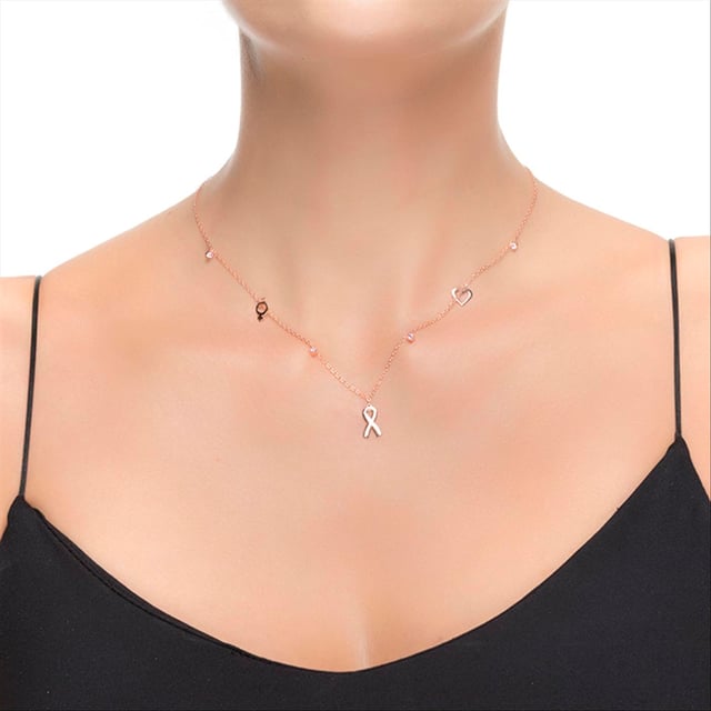 Collar lazo de plata de ley 925 y circonita turmalina rosa con acabado en baño de rodio. Es momento de conocer la mayor virtud de este diseño: EL LAZO CONTRA EL CANCER que tienen el poder transformar un look clásico en una propuesta cargada de carácter y personalidad. Diseños realizados cuidadosamente a mano con materiales de primera calidad: circonitas rosas con un baño de oro rosa sobre Plata de Ley 925.  Todo se vuelve a mezclar para un nuevo “golpe” de efecto para la generación beat, siendo el mejor mix de sobriedad newyorker y sensualidad femenina.  Los diseños con personalidad dictan el color y la madre naturaleza: la unión de diferentes materiales y una exquisita disposición de las piezas hacen de esta línea la joya única, definiendo el amor a primera vista, un pas de deux es un dialogo de amor: Un bonito – y eterno- RECUERDO.