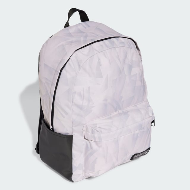 A classic pack with an edgy look. This adidas backpack lends fresh attitude to your casual outfits thanks to a cool allover print. Roomy enough for all your essential gear, it has a zip main compartment, front zip pocket and side slip-in pockets to keep everything organised. Padded adjustable straps add comfort if the bag gets heavy. This product is made with at least 50% recycled materials. By reusing materials that have already been created, adidas help to reduce waste and our reliance on finite resources and reduce the footprint of the products adidas make.  - Dimensions: 15 cm x 36 cm x 44 cm - Volume: 27.5 L - 100% polyester (recycled) - Zip main compartment - Front zip pocket - Side slip-in pockets - Padded adjustable straps  Shipped by adidas