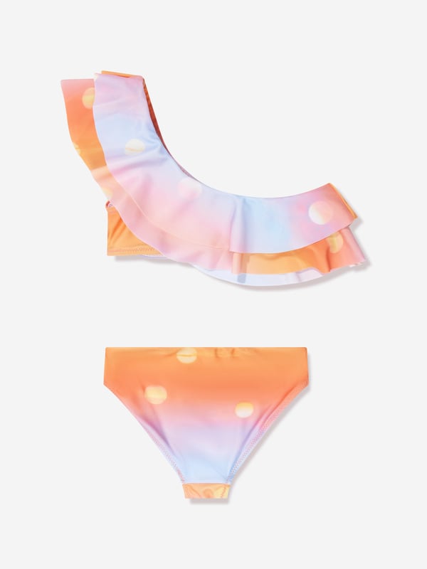 Introducing the Girls Sun Print Nikkie Asymmetrical Bikini In Orange by Molo, an essential add-on to your little girl's summer wardrobe! Here are its standout features:  Boutique Design: Flaunts an asymmetrical cut, lending a trendy, high-fashion look. Vivid Sun Print: The vibrant sun print in orange is playful and attractive, ensuring your little one shines brighter than the summer sun. Premium Quality: Crafted from superior fabric, this bikini promises utmost comfort and an excellent fit. Perfect for Summer: Its radiant colour and quirky design make it an ideal piece for beach days or pool parties.Add this Girls Sun Print Nikkie Asymmetrical Bikini In Orange from Molo to your cart and let your girl embrace summer in style!