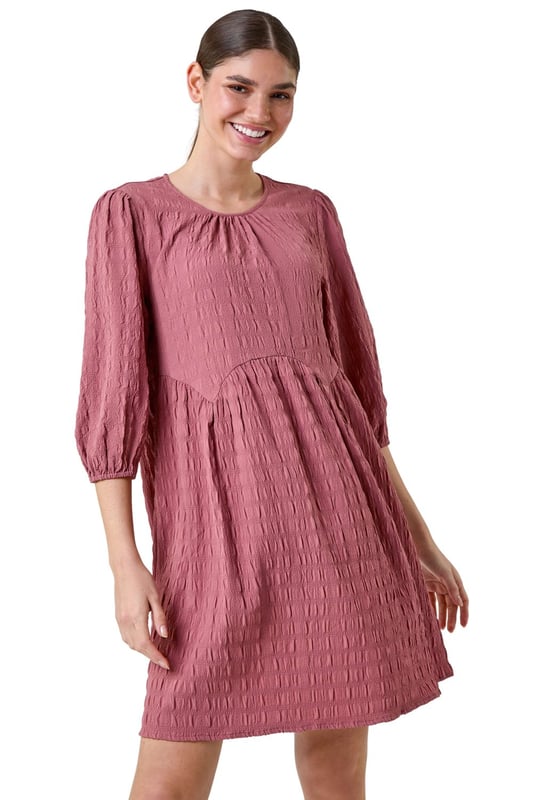 Bubble Textured A-Line Stretch Dress from Roman. Add pretty textures to your everyday collection this season, with this easy-to-wear A-line dress. Crafted from a stretch jersey fabric, this piece features a modest round neckline and 3/4 length sleeves, finished with elasticated cuffs. An empire waistline ensures a flattering and comfortable fit, while the all-over texture provides interest throughout. Pair with sandals and a denim jacket for a laid-back look, or add wedges and a sun hat for a day at the beach club!