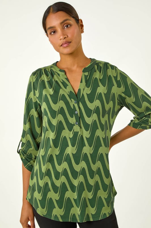 Geometric Print Stretch Blouse from Roman. Elevate your wardrobe this season with our stunning abstract blouse. The bold print and woven silhouette make it versatile for any occasion. The notch neckline, adjustable 3/4 length sleeves and front button details adds a touch of sophistication. Pair it with black jeans and boots for a daytime look or add tailored trousers perfect for those desk-to-dinner days