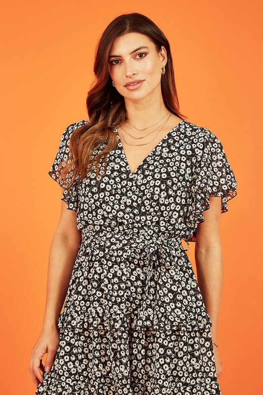 The perfect date night fit, or for brunch with your friends. This Mela floral print skater dress has a wrap over neckline, tie belt and sweet angel sleeves. The tiered ruffly skirt and knee length hem look great paired with trainers for a casual look or heels for a special occasion.