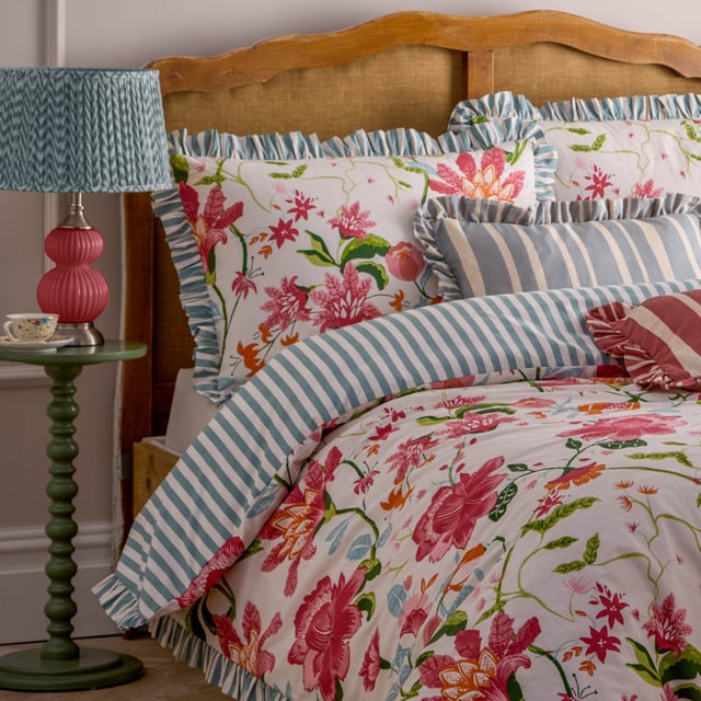 The Claudia Duvet Cover Set features a beautifully mirrored floral pattern with statement hand-painted flowers that delicately intertwine to create a seamless design. The striped reverse offers a classic look and the heritage striped ruffle trim adds an elegant touch. This floral bedding brings organic charm to your bedroom, making it the perfect addition to your decor this summer. 260 x 220cm