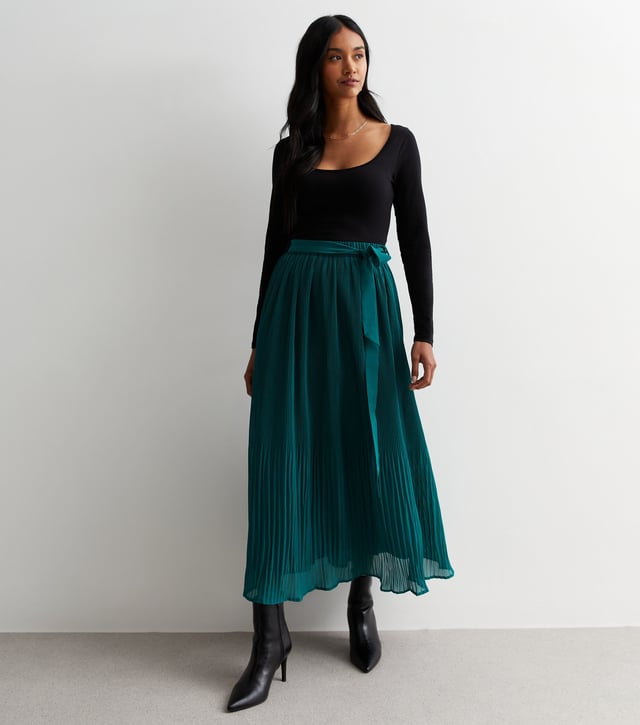 Esta falda midi plisada verde con detalle de cinturón está diseñada por expertos con un corte midi y confeccionada en un tejido vaporoso de tacto ligero con detalles de cinturón. Su silueta contemporánea es favorecedora y atemporal, perfecta para cualquier ocasión.