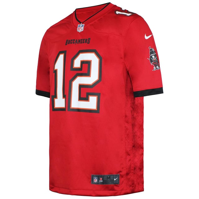 ¿Eres un fan incondicional de los Tampa Bay Buccaneers? Demuestra tu apoyo incondicional al equipo y al legendario quarterback Tom Brady con esta camiseta Tampa Bay Tom Brady Game Jersey. Diseñada por Nike, esta camiseta combina gráficos llamativos con materiales de alta calidad para garantizar que te veas y te sientas lo mejor posible mientras animas a tu equipo favorito.

El ajuste de esta camiseta Nike Game Jersey para hombre es fiel a la talla, ofreciendo un diseño cómodo y entallado que permite libertad de movimientos. Si prefieres un ajuste más holgado, te recomendamos pedir una talla más que tu talla habitual. Para aquellos que planeen llevar capas debajo de la camiseta, se sugiere subir dos tallas para un ajuste más cómodo.

Fabricado en poliéster 100% reciclado, este maillot no sólo muestra tu lealtad al equipo, sino que también contribuye a las prácticas sostenibles. Los paneles laterales de malla proporcionan una transpirabilidad extra, manteniéndote fresco y cómodo durante los momentos intensos de juego. El escudo de la NFL en el cuello añade un toque auténtico, mientras que la etiqueta suspensoria tejida en sarga de satén añade un toque de sofisticación.

El nombre, los números y los logotipos serigrafiados en la camiseta garantizan durabilidad y colores vibrantes que no se destiñen con el tiempo. Ya estés en el estadio, viéndola desde casa o fuera de casa, esta camiseta muestra con orgullo tu amor por los Tampa Bay Buccaneers y su emblemático quarterback, Tom Brady.

No pierdas la oportunidad de representar a tu equipo con estilo. Hazte con la Tampa Bay Tom Brady Game Jersey y conviértete en el fan definitivo de los Buccaneers. Deja que el mundo sepa cuál es tu lealtad y anima a tu equipo hasta la victoria con esta icónica prenda.