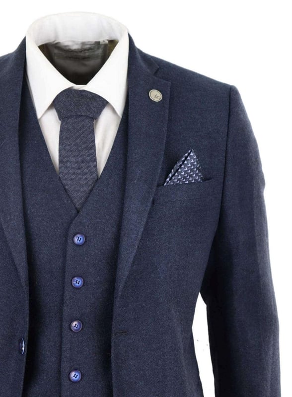 Ein blauer Anzug ist ein Grundbestandteil der Garderobe eines jeden Mannes und dieser hier ist keine Ausnahme von dieser ungeschriebenen Regel. Scharf, elegant und raffiniert – sehen Sie gut aus mit diesem hochwertigen dreiteiligen marineblauen Woll-Tweed-Anzug mit Slim-Fit-Schnitt, engerer Passform an der Brust und schmaler geschnittenen Hosen. Die Zwei-Knopf-Jacke fällt wunderschön und hat eine halbe Canvas-Konstruktion, die sich Ihrer Körperform anpasst, je mehr Sie sie tragen. Mit Taschenpaspeln aus Samt, geknöpften Manschetten und einem einzelnen Rückenschlitz verleihen dem Anzug einen klassischen Hauch von Raffinesse. Eine passende Tweedweste vervollständigt den Dreiteiler im einreihigen Daunenstil mit klassischen maßgeschneiderten Taschen und einem Rückenversteller, um sicherzustellen, dass Sie Ihre ideale Passform kreieren können. Der Anzug ist immergrün und zeitgemäß zugleich und ermöglicht es Ihnen, den ganzen Tag über gut auszusehen. Kombinieren Sie es mit einer passenden Weste, einem weißen Hemd und Schuhen für ein elegantes Finish.