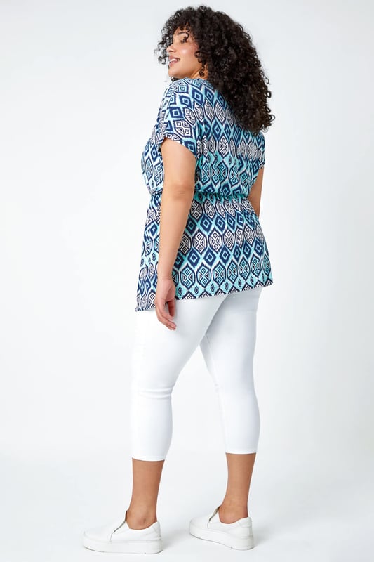 Curve Aztec Print Stretch Top from Roman. Top of the tops, this trendy tunic top is sure to become a favourite. Ideal for Spring, this Curve blouse has a flattering fit and flare shape with a comfortable elasticated waist. The bold aztec print is getting us holiday ready whilst the classic short sleeve shape keeps you cool all Summer long. Style with cropped stretch trousers and sandals for jet-set-ready styling this season.