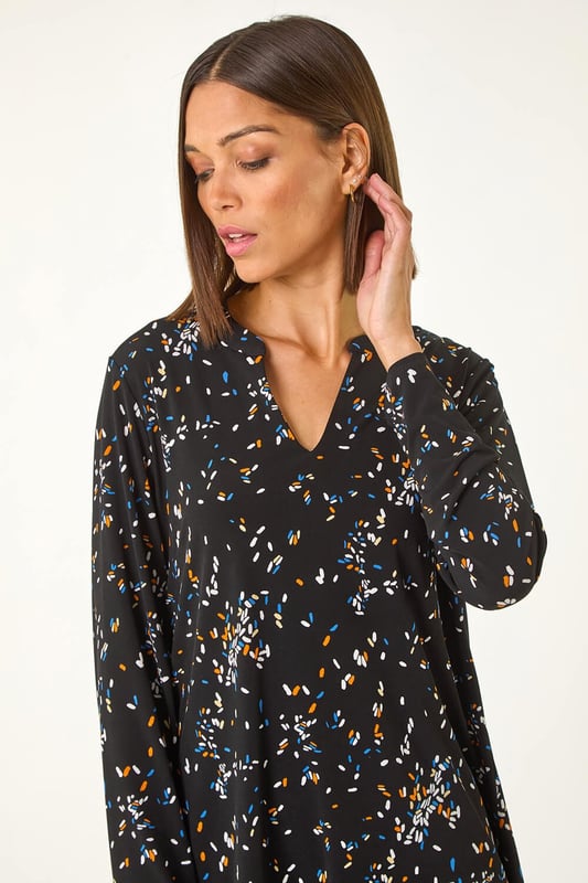 Abstract Print V-Neck Tunic Top from Roman. Inject some fun into your wardrobe with this abstract print tunic top, perfect for the Autumn Winter season. The flattering v-neckline and long sleeves will keep you warm and stylish. Crafted from stretchy jersey fabric, this top features a vibrant abstract print with a contrasting hem, all designed in a trendy tunic shape. Simply pair with jeggings and ankle boots for a fashionable fall look.