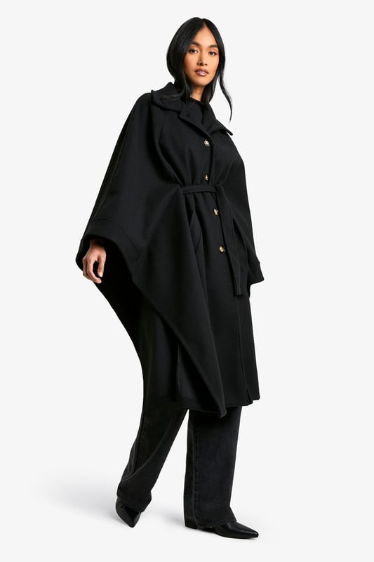 Dramatic cape-style silhouette for a bold statement
        Oversized collar adds a touch of sophistication
        Belted waist for a customisable fit
        Functional side pockets for practicality
        Versatile length suitable for various outfits
    
    Make a striking entrance with this captivating cape in wool-look fabric. Perfect for the fashion-forward woman who craves both style and comfort, this piece effortlessly combines drama with versatility. The oversized collar and flowing silhouette create an air of elegance, while the belted waist allows you to customise your look. Ideal for casual outings or family gatherings, pair it with wide-leg trousers and a simple top for a chic ensemble. The side pockets add a practical touch, making it perfect for those days when you want to travel light. Whether you're heading to a coffee date or a weekend market, this cape will ensure you stand out from the crowd while keeping you cosy. Its adaptable nature means it can be dressed up or down, making it a valuable addition to any wardrobe.