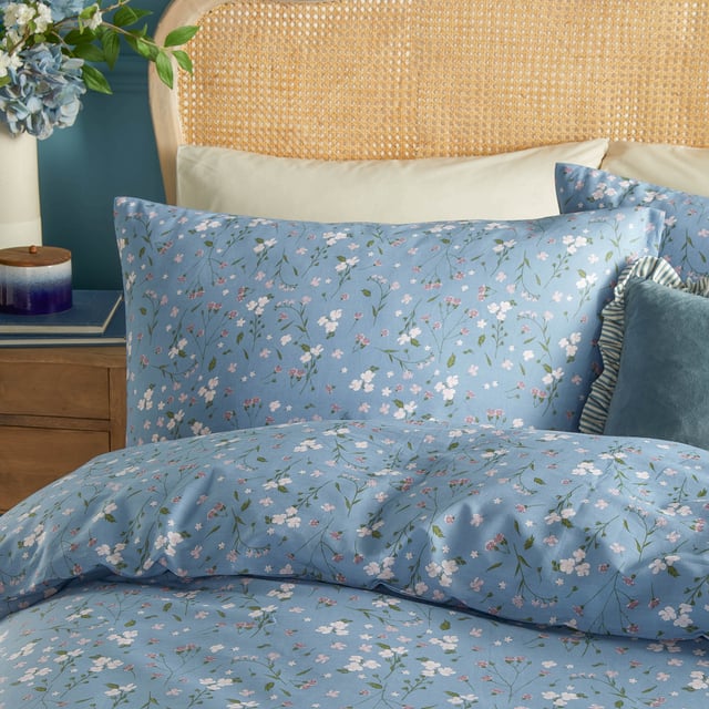 Transform your bedroom into a serene retreat with the Bronte Floral Duvet Cover Set. Crafted from 100% cotton and featuring a 144-thread count, this duvet cover combines comfort with timeless elegance. The classic English garden ditsy print showcases delicate lilac forget-me-nots and subtle foliage, offering a refined touch that speaks to lovers of nature and understated beauty. The same exquisite design graces both sides, allowing it to stand alone as a statement piece. With Bronte, experience the perfect blend of sophistication and natural allure that invites tranquillity and style into your living space. 200 x 200cm