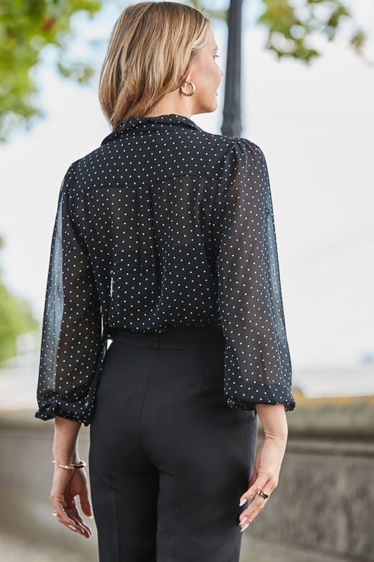 This one works as hard as you doAll-over spot print that's always on-trendGorgeous ruffle detail takes it from desk to dinner We've kept the sleeves sheer and added a cami for coverage Longline hem you can wear loose or tucked inIt looks so chic with cigarette trousers and courts