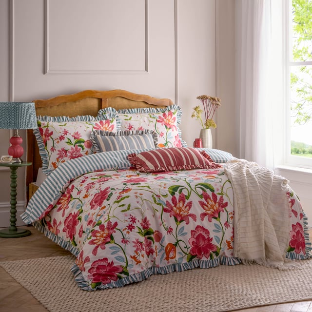 The Claudia Duvet Cover Set features a beautifully mirrored floral pattern with statement hand-painted flowers that delicately intertwine to create a seamless design. The striped reverse offers a classic look and the heritage striped ruffle trim adds an elegant touch. This floral bedding brings organic charm to your bedroom, making it the perfect addition to your decor this summer. 260 x 220cm