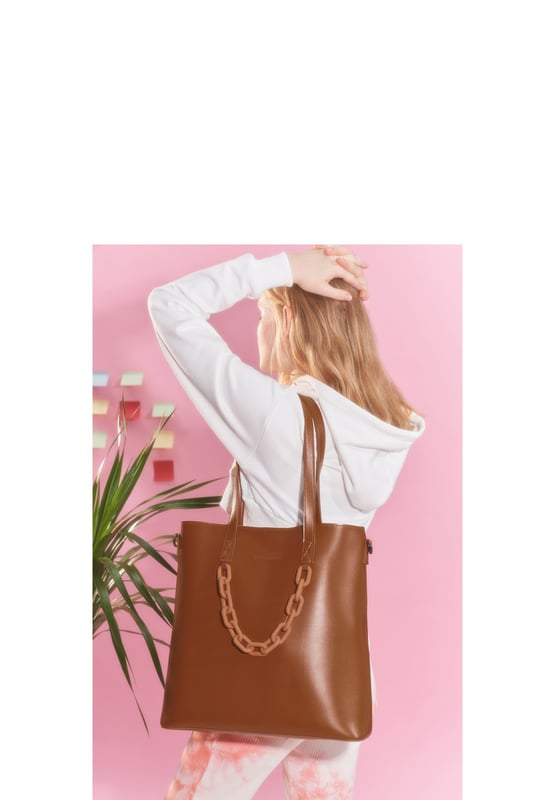This beautiful bag is a statement piece from a busy day at work to a relaxing day shopping, this is the perfect, spacious tote. With the luxurious soft PU leather and minimalistic look this will easily become your everyday bag on the go. The optional shoulder strap allows you to have 2 styles in one for maximum comfort. While also featuring a large zip top inner pouch to keep all your valuables safe. Features: , Claudia Canova blind debossed logo, Two grab handles, Removeable shoulder strap, Portable large inner pouch with secure zip opening, Magnetic clasp fastening to the main compartment, Gunmetal hardware, Soft chain detailing Style Ref: 84303 TAN