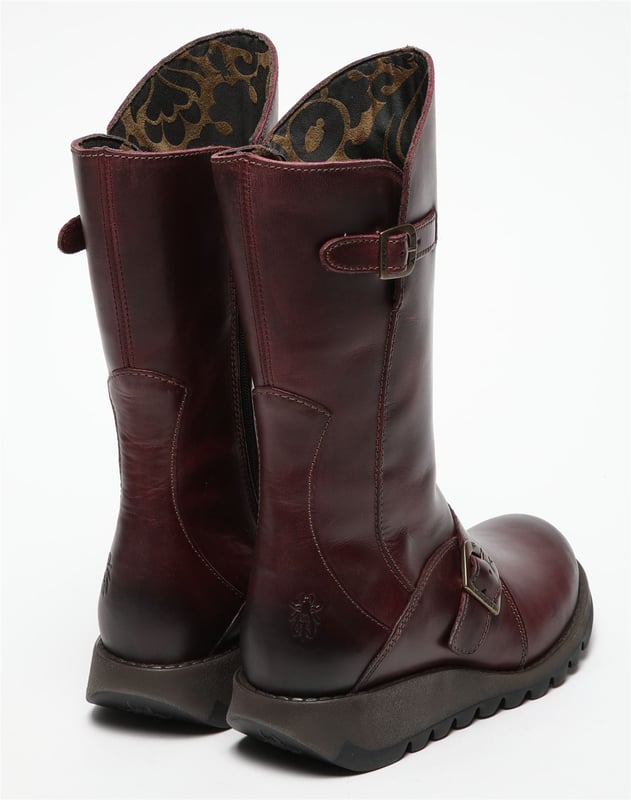 Las botas de cuero con hebilla MES 2 de Fly London para mujer de la línea Sminx son una elegante incorporación a cualquier guardarropa. Estas botas cuentan con una elegante correa lateral baja con una hebilla de marca de forma contemporánea, complementada con una segunda hebilla justo debajo de la línea superior moldeada. El logotipo característico de Fly London está grabado en el tacón alto con paneles. Fabricadas con parte superior de cuero de primera calidad, forro de microfibra y plantilla, ofrecen estilo y comodidad. La suela de goma TR duradera y el tacón de 3,5 cm garantizan la estabilidad, mientras que una cremallera lateral proporciona un fácil acceso. Parte superior: cuero, forro: microfibra, plantilla: microfibra, suela: goma TR, altura del tacón: 3,5 cm, cierre de cremallera, detalles de hebilla, logotipo grabado en el talón.