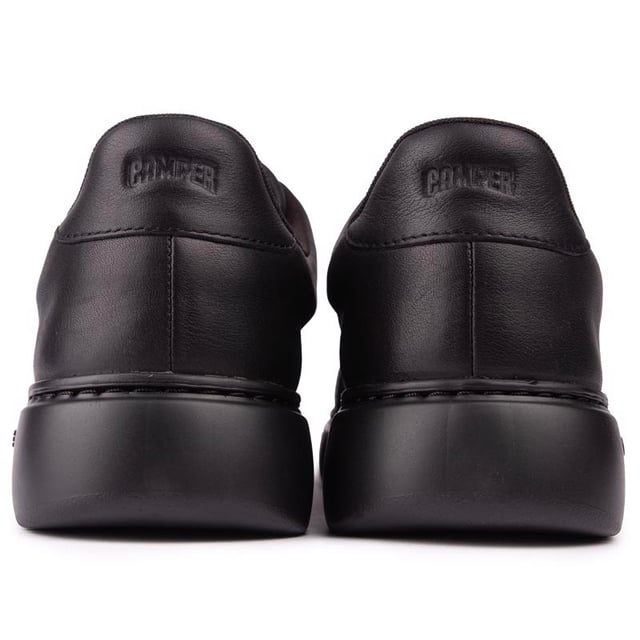Runner K21 es la última incorporación a la colección Runner de Camper con un enfoque de inspiración retro y mayor volumen. Esta zapatilla de cuero negro para hombre tiene una plantilla extraíble OrthoLite® Recycled™ y suelas XL EXTRALIGHT® Organix™ (30 % de caña de azúcar de origen biológico).