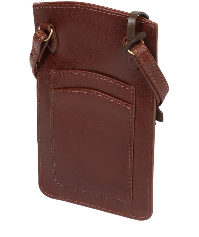The 'Siren' from Conkca London is handcrafted from genuine leather for a beautiful finish. This open-top phone bag is the perfect way to keep your phone on your person whilst keeping your hands free. The interior is lined with natural and untreated 100% cotton. Includes a cotton-lined slip pouch on the front and two card slots on the rear, ideal for maintaining an organised bag. Comes with an adjustable leather strap with a drop length of 70cm, alongside gold metal fittings. Adorned with the iconic Conkca logo and charm.