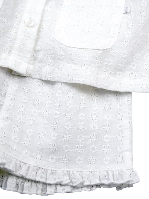Our beautiful woven embroidery anglaise shortie pyjamas for girls are a lovely choice for Spring. This textured pure-cotton set has a button through top, which is beautifully detailed with a Peter-Pan collar, puff sleeves, engraved buttons and pockets, and woven shorts finished with a lovely frill hem. It makes a wonderful gift for little ones.

Design & Fit

Classic white short sleeve top and shorts
Short-sleeve button through top
Peter Pan Collar
Elasticated waistband
Easy, pull-on style
Fabric and Care

100% Cotton 
Machine wash
Safety warning: keep away from fire