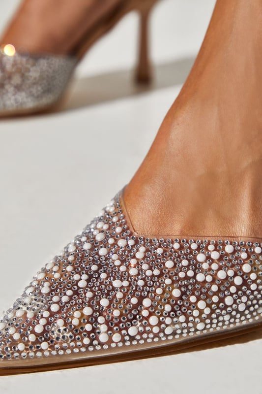 Exquisite pointed toe court shoes with sling back strap
Lavishly embellished with sparkling diamantes and lustrous pearls
Elegant stiletto heel for a flattering leg-lengthening effect
Slip-on design for effortless on and off
textile upper for a luxurious look and feel

Radiate sophistication and elegance at your next special occasion with these stunning court shoes. The lavish diamante and pearl embellishments exude a glamorous aesthetic, perfect for weddings, formal events or the races. Pair them with a tailored dress or jumpsuit for a refined, polished ensemble that commands attention. With their pointed toe and stiletto heel, these shoes will elongate your silhouette while adding a touch of opulence to your look.