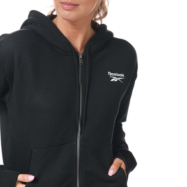 Womens Reebok Identity Zip- Up Track Top in black.- Drawcord-adjustable hood.- Long sleeves with ribbed cuffs.- Full zip fastening.- Kangaroo pocket.- Ribbed hem.- Small logo.- Oversize fit.- Main Material: 80% Cotton  20% Polyester (Recycled). Rib Part: 95% Cotton  5% Elastane. - Ref:GL2561