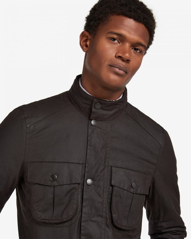 Barbour Corbridge Wax Jacket
The Corbridge is a rugged utility-style men's waxed jacket updated with a contemporary engineered fit. With winter in mind, this multi-functional jacket is constructed in Barbour's hardy 6oz Sylkoil waxed cotton with a comfortable, lightweight Nylon lining quilted to 50g wadding, for additional warmth. The corduroy-lined funnel collar features an integral Nylon hood complete with adjustable toggles for a perfect fit, offering wet-weather defence when needed but easily stowed away in the collar on dry days. Built to offer comfort and protection to those who are active outdoors in any weather, the Corbridge benefits from adjustable cuffs, a robust two-way zip, a storm fly front with stud fastenings and an action back. The classic four-pocket detail adds a stylish, practical feature that keeps essentials safe and hands free. Available in a choice of three versatile colours. As this is a slim fitting jacket, we would advise purchasing the next size up than you would normally choose.

Tailored Fit
Barbour tonal embroidery to left pocket
Outer: 100% cotton (waxed)
Inner: 100% polyamide
6oz waxed cotton
Do not wash
Sponge clean only
Back length: 78.8cm - 83cm

MWX0340