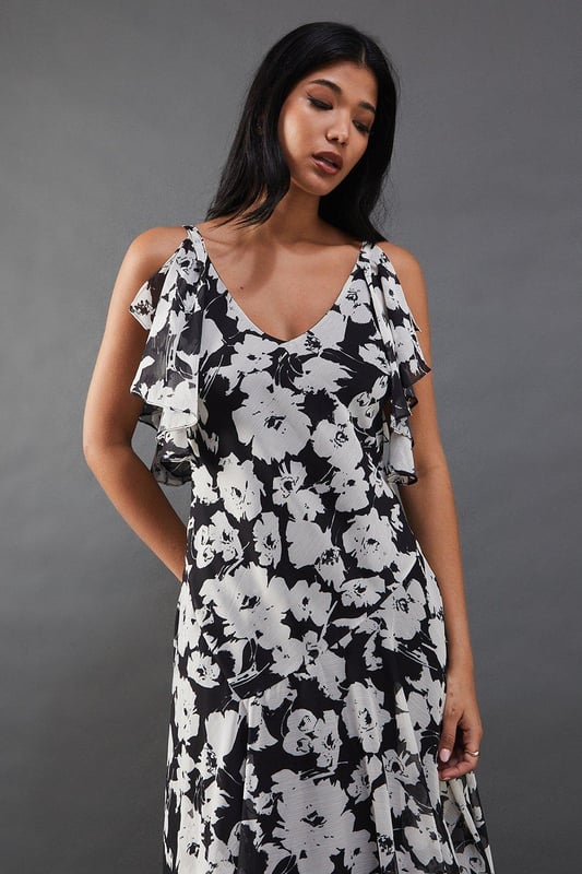 Strappy chiffon midi dress with bold floral print
        Layered tendril design for added movement and dimension
        V-neckline with delicate spaghetti straps
        Cold-shoulder detail with fluttery sleeves
        Tiered skirt with asymmetrical hemline for a dramatic silhouette
    
    Make a statement at your next night out with this captivating floral chiffon midi dress. The striking print and layered tendril design create a mesmerising effect as you move, ensuring all eyes are on you. The strappy neckline and cold-shoulder detail add a touch of allure, while the tiered skirt with its asymmetrical hemline offers a contemporary twist on a classic silhouette. Perfect for cocktail parties or dancing the night away, this dress pairs beautifully with strappy heels and statement earrings. For a more relaxed look, throw on a leather jacket and ankle boots. The versatile design allows for endless styling options, making it a go-to piece for various occasions. Whether you're heading to a rooftop bar or a trendy restaurant, this dress will help you radiate confidence and style.