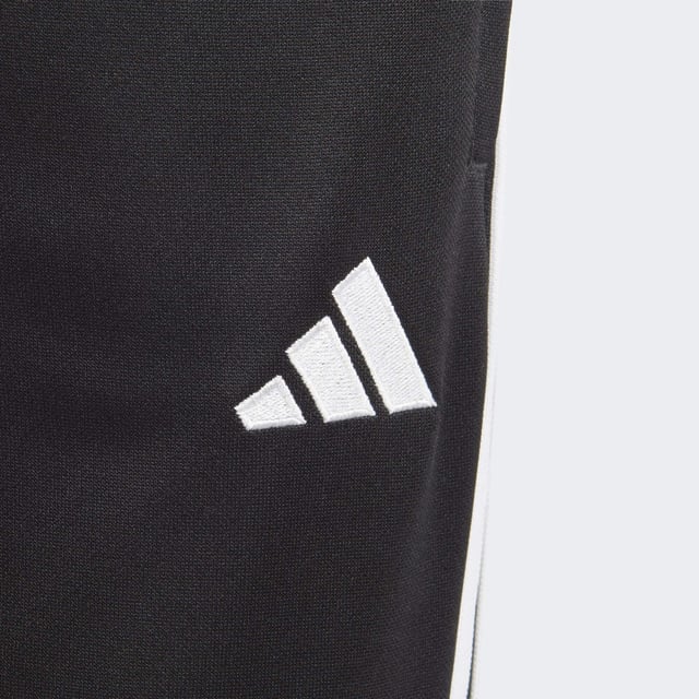 Essential training gear from adidas. Before you hit the pitch for that chilly winter session, layer up in these juniors' Tiro 23 Club football pants. Their slim, streamlined fit and moisture-absorbing AEROREADY will keep you flying through sprints and rondos. Once you reach perfect temperature, ankle zips make pulling them off over your boots a breeze.Made with 100% recycled materials, this product represents just one of adidas' solutions to help end plastic waste.  - Slim fit - Mid-rise elastic waist with drawcord - 100% polyester (recycled) - AEROREADY - Front zip pockets - Ankle zips  Shipped by adidas