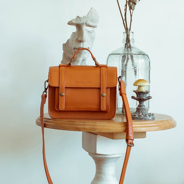 Tradition meets modernity! With the brand new Satchel handbag, Victoria Hyde London quotes traditional satchels and adapts the style of the past to our modern times. The brown handbag opens with two golden buttons. When you open the bag, three compartments, including one with a zip, immediately catch your eye. This means your essentials are always perfectly stowed away and organised. Your new favourite piece can be worn casually as a crossbody bag, cool over the shoulder or elegantly in the hand. The golden accents of this brown handbag stylishly round off the look of the bag. Dimensions: 19cm x 15cm x 6cm, Length of the carrying strap: 96.5cm,  Height of the carrying strap: 47cm