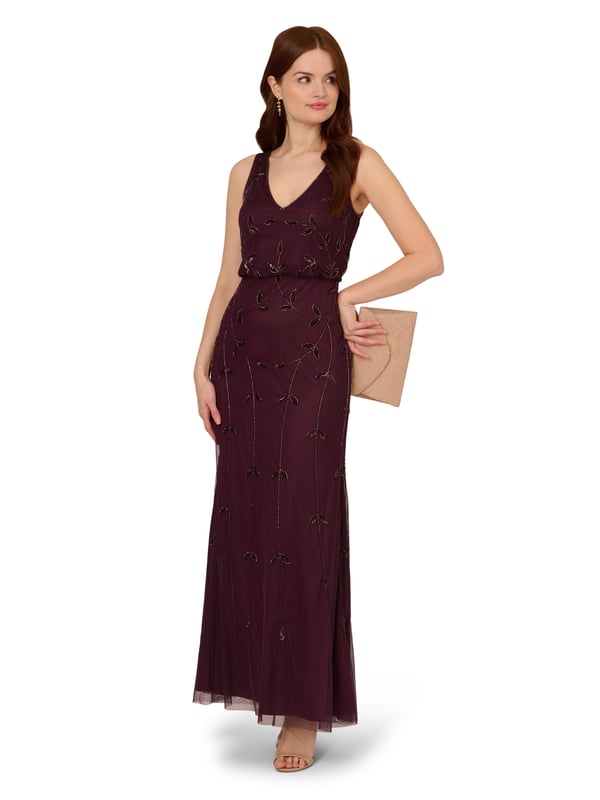 Put a little sparkle on display when you rock this sleeveless blouson gown. This formal dress features a sleeveless blouson bodice, deep v-neckline and back, and a soft skirt. Crafted with a luxe mesh fabric that is fully lined, this evening gown is embellished with sequin and beaded vines. The neckline and armholes of this gown are trimmed in beading for added sparkle. A hidden zipper closure at the centre back completes the design. This sleeveless beaded gown is a stunning look for a wedding guest or bridal party and pairs well with neutral or metallic accessories.