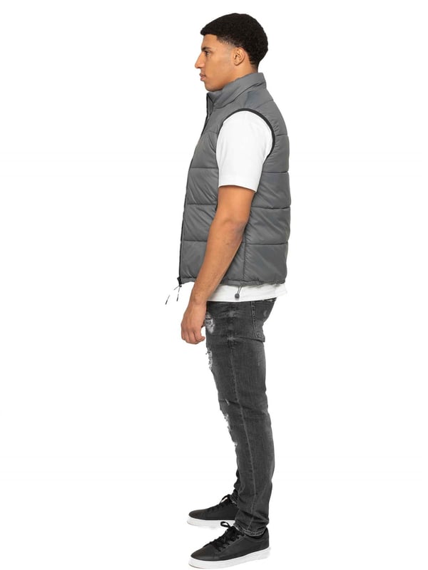 Embodying both fashion and function, the Enzo Mens Puffer Gilet boasts a water-resistant design and a high neck for added warmth. It also offers secure storage with zipped side pockets, and a custom fit with its elasticated hem and adjustable toggle. The full zip-up front and lined interior provide ultimate comfort and practicality. With a EZ branded badge on the chest, this gilet is crafted from durable 100% polyester and is conveniently machine washable.