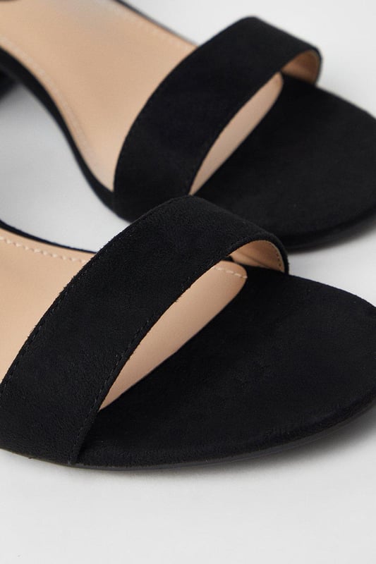 Wide fit design offers a comfortable and accommodating fit
Barely-there strappy silhouette with minimalist appeal
Mid block heel provides a modest lift and walkable height
Faux leather upper exudes a look and feel
Ankle strap with buckle closure ensures a secure fit

These versatile sandals are perfect for casual daytime outings or relaxed evening affairs. Pair them with a flowy midi dress or cropped trousers for a chic, on-trend look that transitions seamlessly from brunch with friends to an evening baby shower. The neutral hue complements a variety of ensembles, allowing you to showcase your personal style effortlessly.