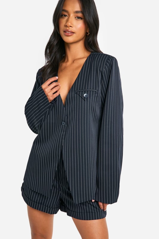 Petite Collarless Pinstripe Tailored Blazer Collarless design for a modern twist on classic tailoring
Pinstripe pattern adds a sophisticated touch
Tailored fit flatters the petite frame
Functional chest pocket for added utility
Versatile piece suitable for both work and casual settings
This petite collarless pinstripe blazer from Boohoo is a versatile addition to any wardrobe. The tailored fit is designed to flatter smaller frames, while the collarless neckline offers a contemporary twist on traditional suiting. Style it as seen on the model with matching shorts for a coordinated look that's perfect for daytime events. For a more casual vibe, pair it with your favourite jeans and trainers. The blazer's adaptability makes it ideal for various occasions, from family gatherings to casual office days. Layer it over a crisp white tee or a silky camisole to switch up your look. The pinstripe pattern adds a touch of sophistication, making this blazer a go-to piece for those wanting to make a stylish statement without compromising on comfort.