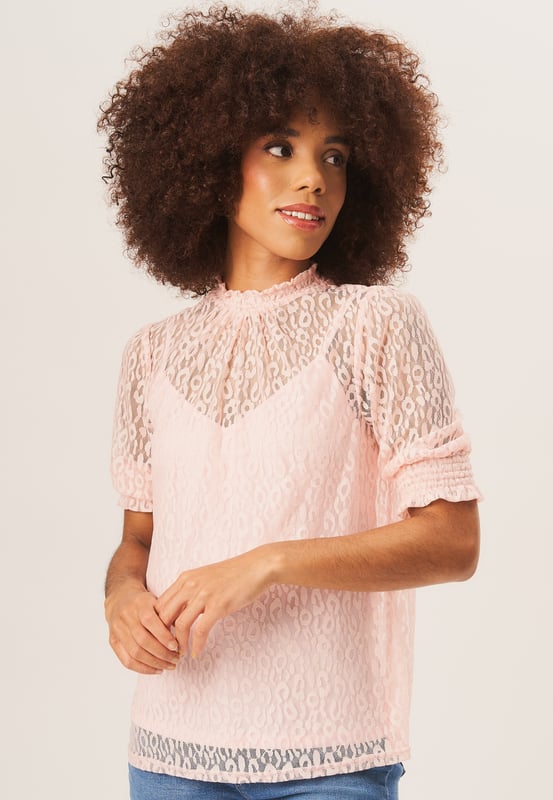 Eleva tu estilo con nuestra blusa holgada de encaje y cuello alto negra. Este elegante top combina un moderno cuello alto y delicados detalles de encaje para un look vanguardista. El corte holgado permite un uso cómodo y sin esfuerzo, lo que lo convierte en una prenda imprescindible para cualquier armario elegante.