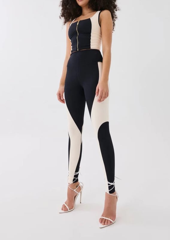 A high-rise full length legging cut in a soft compressive matte blend of recycled nylon and elastane. With built in waistband support, this style is ideal for low impact training and your street-sport wardrobe. A contrast beige curved panel detailing throughout and a P.E Nation silicon badge at the ankle for a minimal finish.