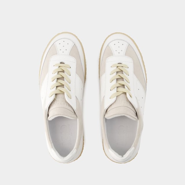 De MM6 6 Court Sneakers Maison Margiela belichamen casual elegantie met hun strakke witte leren ontwerp. Ontworpen om stijl en comfort te combineren, zijn deze sneakers voorzien van de verfijnde handtekening van het modehuis en geven ze een eigentijdse touch aan elke outfit. De 6 Court Sneakers zijn perfect voor een verfijnde urban look en weerspiegelen de avant-gardistische esthetiek en uitzonderlijke kwaliteit van het merk. Kleuren: Wit - Blanc. Hoofdmateriaal: generfd kalfsleer. Materiaal zool: rubber. Materiaal voering: leer. Sluiting: veters bovenaan. Tipvorm: rond. Pasvorm: op maat - Maatvoering: Europees.