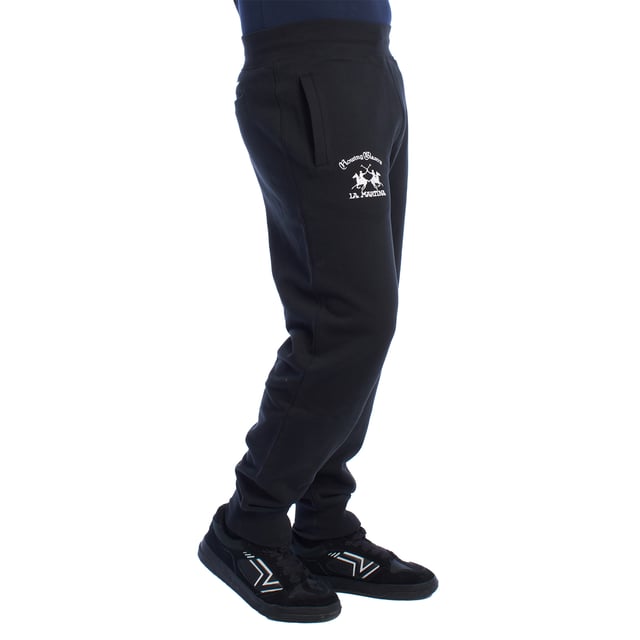Pantalón de chándal para hombre de La Martina.

Estilo y elegancia se combinan en este pantalón deportivo de La Martina, diseñado para los hombres que buscan comodidad sin renunciar a un diseño exclusivo. 

Detalles:

- Fabricado en algodón de alta calidad, suave y transpirable, para garantizar comodidad durante todo el día.
- Cintura elástica que asegura un ajuste cómodo y seguro en cualquier actividad.
- Bordados exclusivos de La Martina en ambos lados del pantalón, destacando el logotipo y un león rojo icónico que aportan un detalle único y sofisticado.
- Bolsillos laterales amplios y funcionales, ideales para guardar pequeños objetos de manera práctica.
- Bolsillo trasero de ribete con bordado decorativo, combinando funcionalidad y estilo elegante.
- Corte relajado con puños en los tobillos.

Este pantalón deportivo hombre de La Martina es la elección ideal para quienes buscan una prenda que combine confort, diseño exclusivo y detalles únicos como sus bordados distintivos. Perfecto para lucir con estilo en el día a día.
 Composición: 100% Algodón
 Cuidados:
- Lavar máximo a 30°C en ciclo suave.
- No usar lejía ni blanqueadores.
- No secar en secadora.
- Planchar a baja temperatura si es necesario, evitando los bordados.