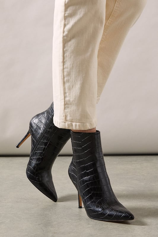 Sleek pointed toe design for a sophisticated silhouette
        Textured faux leather with a chic crocodile-inspired pattern
        Stiletto heel measuring between 7-9cm for an elegant boost
        Ankle-length style with a side zip for easy wear
        Versatile day-to-night boot suitable for various occasions
    
    The Corsica Pointed Stiletto Ankle Boots from Wallis are the epitome of versatile glamour. These striking boots showcase a refined pointed toe and a sleek stiletto heel, perfect for the woman who appreciates sophistication with a modern edge. The textured faux leather exterior adds a touch of luxury, while the crocodile-inspired pattern lends an air of exotic allure. Ideal for transitioning from day to evening, these boots can be styled with tailored trousers and a crisp blouse for a polished office look, or paired with a flowing midi dress for an elegant dinner ensemble. The ankle-length cut offers flexibility in styling, working beautifully with both trousers and skirts. Whether you're heading to an important meeting or a night out with friends, these Wallis boots will ensure you step out in style and confidence.