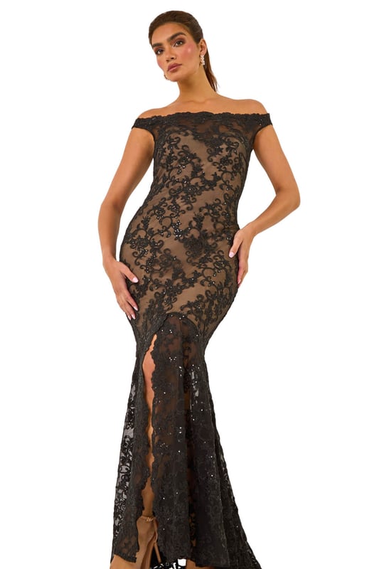 Lace Scallop Edge Front Split Maxi Dress from Roman. Get ready to make a statement in our stunning lace maxi dress. The feminine bardot neckline is adorned with delicate scalloped lace details, adding a touch of elegance to the look. Crafted from a stretch woven fabric, this bodycon dress hugs your shape beautifully and finishes at a flattering maxi length with a mermaid edge and front split for added drama. Pair with heels and a bolero for an unforgettable look!