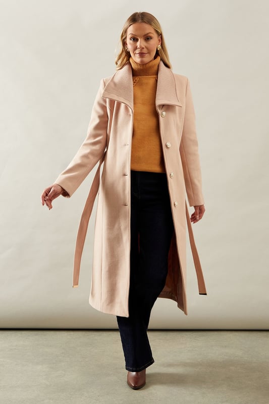 Elegant knitted collar for added sophistication
        Wrap design with button-through closure for versatile styling
        Long length offers maximum coverage and warmth
        Belted waist creates a flattering silhouette
        Functional side pockets for practicality
    
    This Wallis Knitted Collar Button Through Wrap Coat is the epitome of refined elegance. Perfect for the woman who appreciates sophistication without compromising on comfort, this coat is a versatile addition to any wardrobe. The wrap design allows for customisable fit, while the button-through closure adds a touch of classic charm. Style it over a sleek midi dress and pair with heeled boots for a polished look at formal events. For smart casual occasions, layer it over tailored trousers and a fine knit jumper, completing the ensemble with leather ankle boots. The long length and belted waist not only provide warmth but also create a striking silhouette that's sure to turn heads. Whether you're attending a business meeting or heading to a sophisticated dinner, this coat will ensure you look impeccably put-together while feeling effortlessly comfortable.