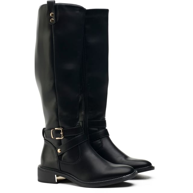 Las botas de montar Joni de SOLESISTER combinan el estilo clásico de montar a caballo con un diseño lujoso de rodilla alta y un atractivo urbano contemporáneo. Las elegantes hebillas de metal dorado con correas alrededor del tobillo, el lujoso adorno de metal dorado en el talón y los delicados detalles en la parte superior de la caña completan la estética urbana con aires ecuestres.